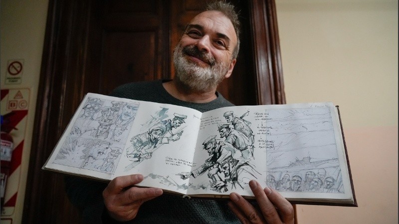 El autor posando con viñetas de su nueva obra basada en un submarino nazi arribado a la Argentina.